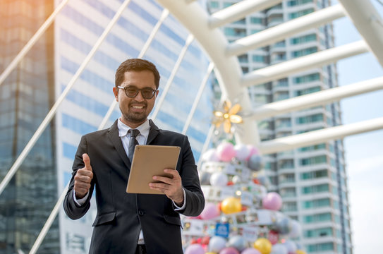 Confident men in expensive suit working on digital tablet while standing on BTS station 