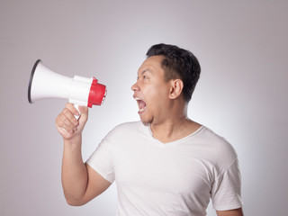 Young Man Shouting with Megaphone, Angry Expression