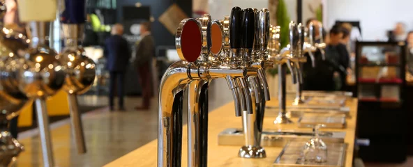 Deurstickers Kroeg biertappen opgesteld op de toonbank van een pub