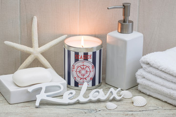 maritime spa still life with nautical candle, soap, towels seashells and word relax