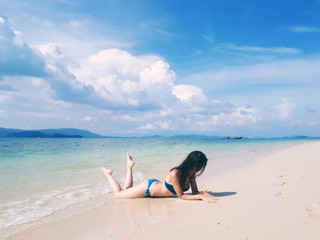 Beautiful woman in bikini laying on the paradise beach