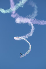 Fototapeta premium Parachutist with spiral clouds of smoke over San Diego, California