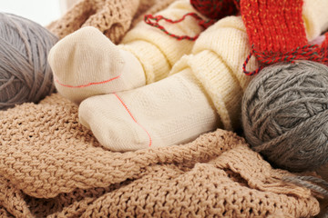 Fototapeta na wymiar Child legs in warm socks are on a window sill with wool yarns.