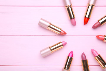 Many pink lipsticks on pink background, close up