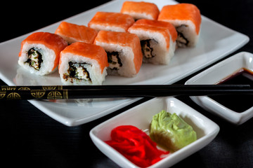 Traditional Japanese cuisine. Philadelphia sushi roll made of fresh salmon, avocado and cream cheese with black rice