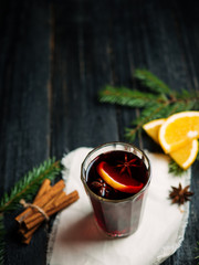 Christmas mulled wine on a wooden table with Christmas tree branches, cinnamon and anise