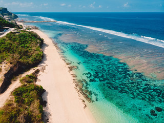 Aerial view of tropical beach with turquoise ocean and waves