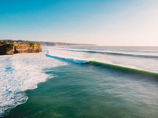 Aerial shooting of big stormy waves at sunset. Ocean waves in Bali