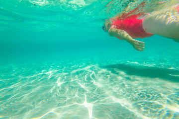 Female apnea underwater with pink wetsuit. Woman snorkeler swims in Denmark, Western Australia....