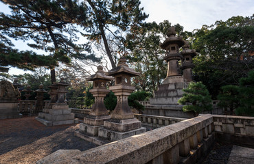Fototapeta na wymiar Ancient stone lanterns outside Japanese shrine