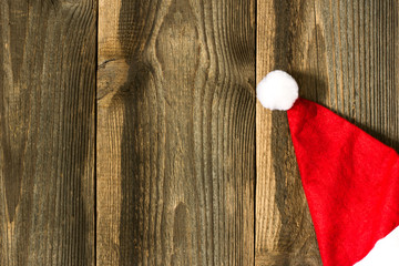 Obraz na płótnie Canvas Santa's hat on wooden planks. Christmas background.