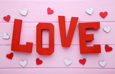 Red letters love on pink wooden background. LOVE word.