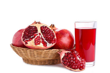 Ripe pomegranates on basket and glass of juice isolated on white background
