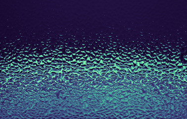 Obraz premium Blue abstract water drops background. Violet green wet glass, condensate texture background.