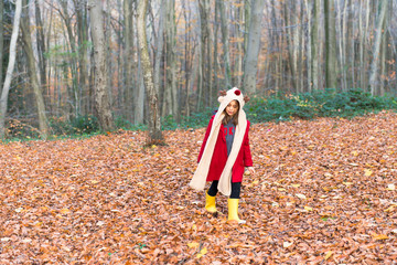 red dressed Cute girl is happy in the forest at autumn season