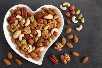 Nuts on a plate in the shape of a heart. - 239297669