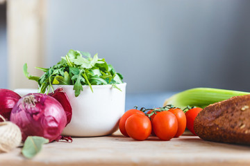 ingredients for salad, fresh vegetables, olive oil on the table in the kitchen. culinary and food concept