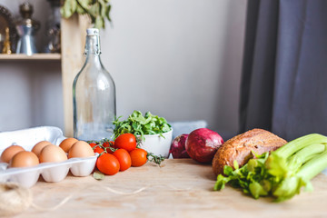 ingredients for salad, fresh vegetables, olive oil on the table in the kitchen. culinary and food concept