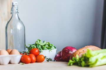 ingredients for salad, fresh vegetables, olive oil on the table in the kitchen. culinary and food concept