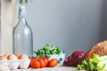 ingredients for salad, fresh vegetables, olive oil on the table in the kitchen. culinary and food concept