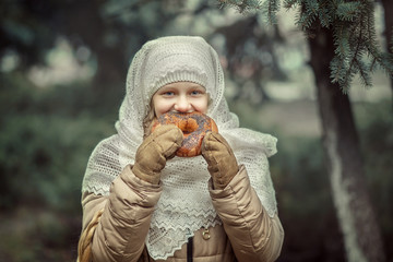 A young girl eats a bagel.