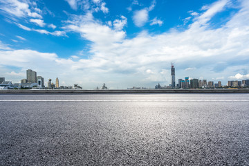 empty asphalt road with city skyline