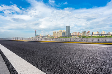 empty asphalt road with city skyline