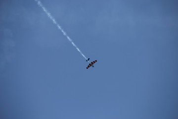 Fototapeta na wymiar Small airplane doing aerial acrobatics in a exhibition