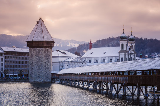 Historic city center of Lucerne with view of famous wooden bridge Kapelbr&uuml;cke (Chapel Bridge) on river Reuss, stone tower Wasserturm and domes of church of Jesuits. Europe, winter Switzerland.