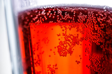 Cherry beer with bubbles in a glass beaker. Photo for design, advertising, banners, beer festival, October fest, posters, prints, shop. Glass mug of tasty fruit beer macro. Liquid texture closely.