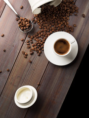 Coffee cup and coffee beans on wooden background. Top view.