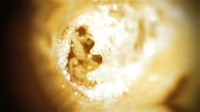 Closeup slow-motion pouring beer in pint glass