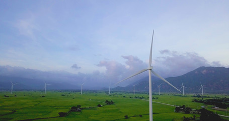 Wind turbine farm and agricultural fields on a summer day. High-quality stock photo image wind turbine in a green field - Energy Production with clean and renewable energy, clean energy concept
