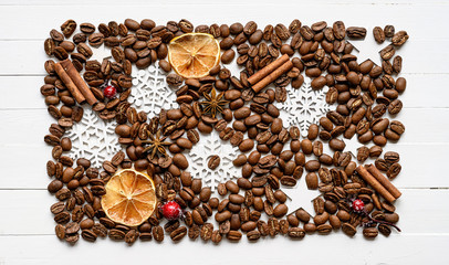 Coffee beans with aroma spices and christmas decorations on white wood planks background