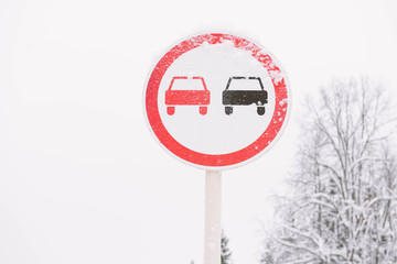 Traffic sign "No Overtaking", on winter road.