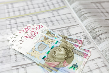Plik banknotów 500 PLN na tle wyników finansowych spółek - obrazy, fototapety, plakaty