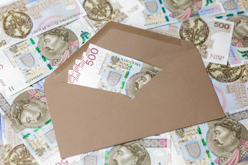 Banknoty 500 PLN w brązowej kopercie na tle z banknotów - obrazy, fototapety, plakaty