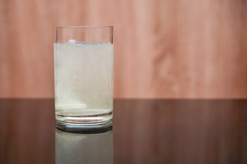 effervescent tablet dissolves in a glass of water on a black table