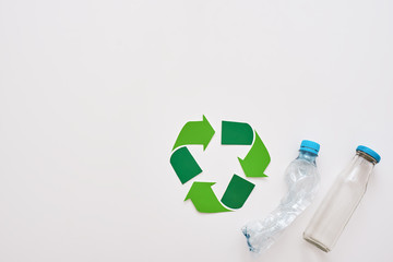 Think about ecology. Isolated recycle symbol and crumple plastic bottles