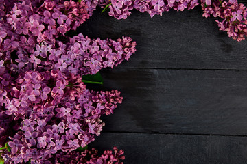 Beautiful lilac flower bouquet on black wooden background.