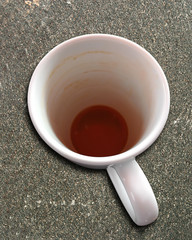 0563 Kaffeetasse auf einer Steinplatte, ausgetrunken bis auf einen kleinen Rest Kaffee