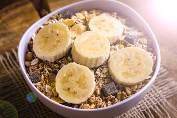 Bowl of cereal with fruit, pieces of banana with oats and cereal.