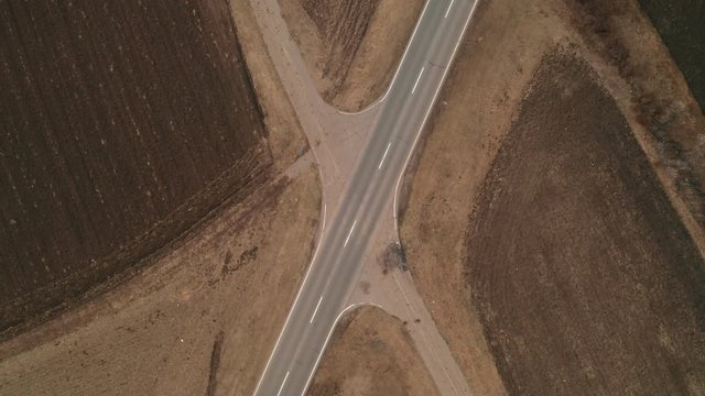 Aerial view of truck on the road through plain countryside from drone pov