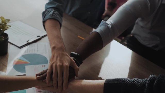 Close up top view of young business people putting their hands together. Stack of hands. Unity and teamwork concept.