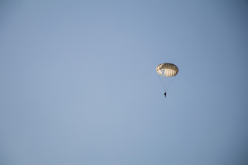Jump of paratrooper with white parachute, Military parachute jumper in the sky.