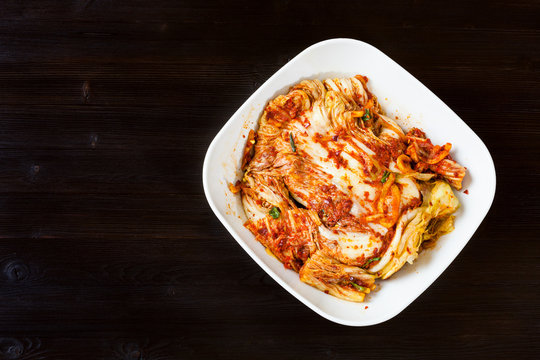 top view of kimchi in bowl on dark wooden table