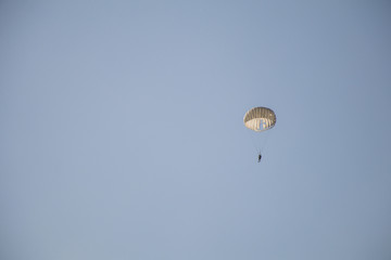 Jump of paratrooper with white parachute, Military parachute jumper in the sky.