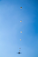 Airplane and paratroopers with parachutes in the sky .Military parachute jumper in the sky.