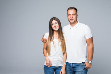 Naklejka premium Portrait of happy couple looking at camera on gray background
