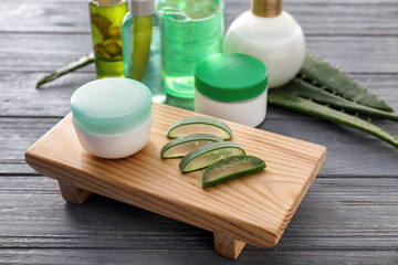 Cosmetic products with aloe on wooden table